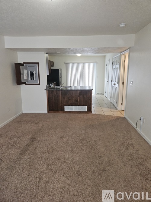 A living room with a carpeted floor and a cabinet.