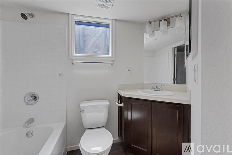 A white toilet sits in a bathroom next to a bathtub.