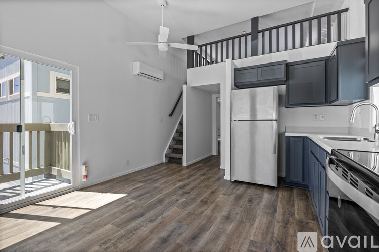 A kitchen with a refrigerator, microwave, and stove top oven.