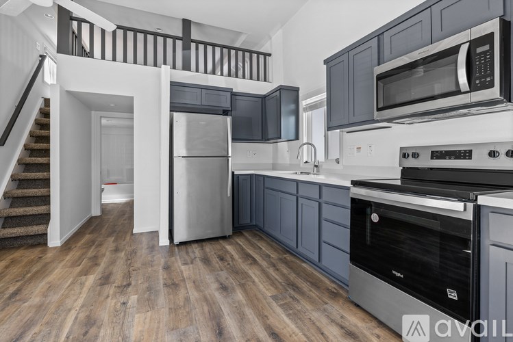 A room with a carpeted floor and a staircase with wooden railings.