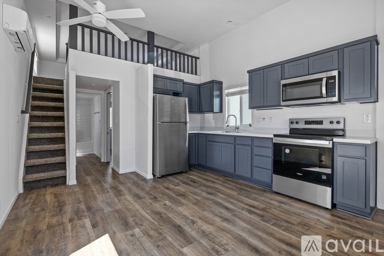 A modern kitchen with dark wood cabinets and stainless steel appliances.