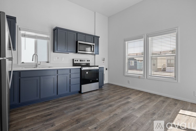 A kitchen with dark blue cabinets and a white fridge.
