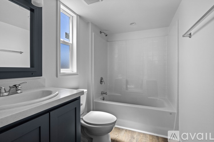A modern bathroom with a toilet, sink, and bathtub.