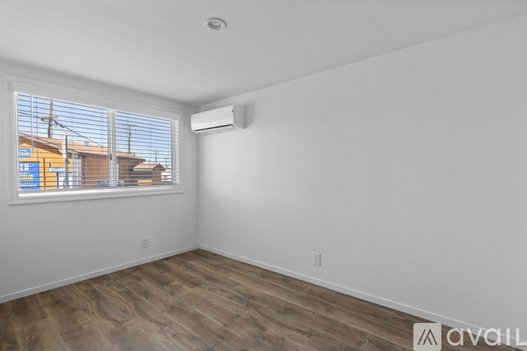 A room with a window and a wall-mounted air conditioner unit.