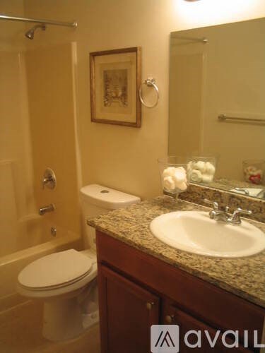 A bathroom with a toilet, sink, and mirror.