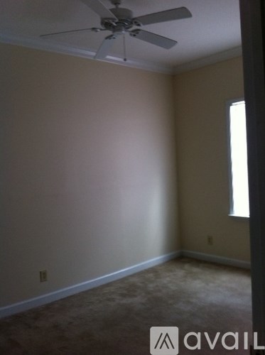 A room with a ceiling fan and a window.