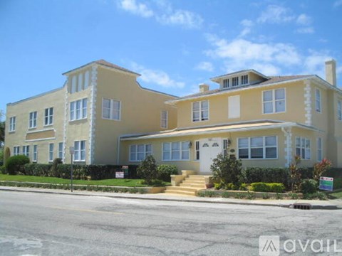 A two-story house with a white front door and a small porch.