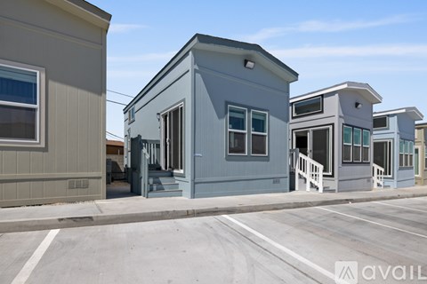 A kitchen with a refrigerator, microwave, and oven is in a house with a staircase.