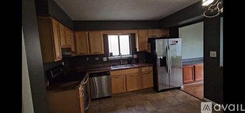 A kitchen with wooden cabinets and a refrigerator.