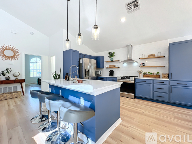 A modern kitchen with blue cabinets and a white island.