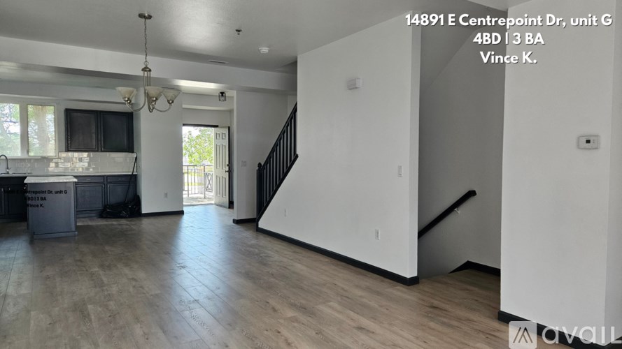A large empty room with a staircase and a window.