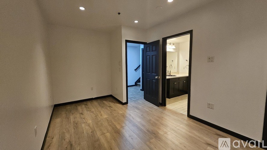 A room with wooden flooring and a black door.