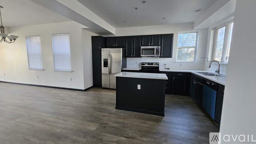 A modern kitchen with black cabinets and a central island.