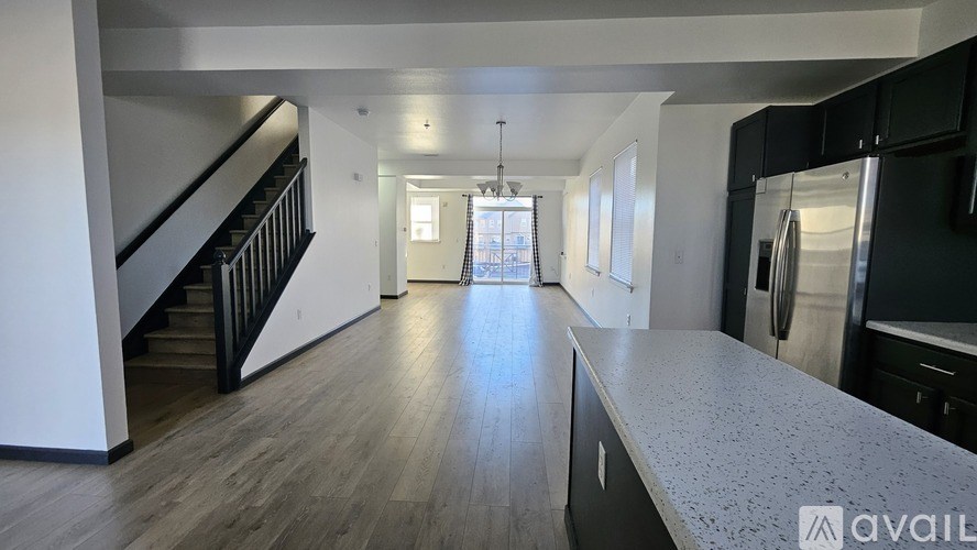 A spacious kitchen with a refrigerator, sink, and cabinets.