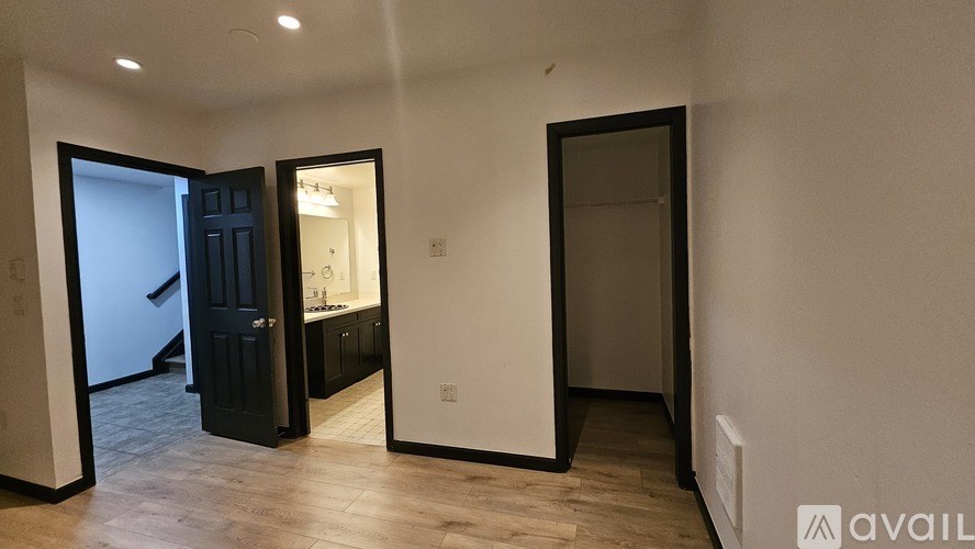 A room with a black door and a white wall.