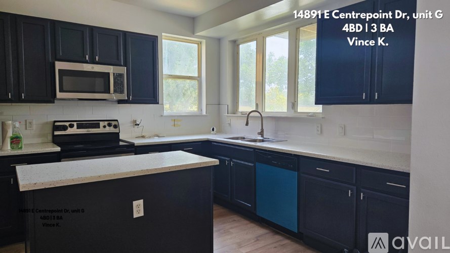 A kitchen with black cabinets and a white countertop.