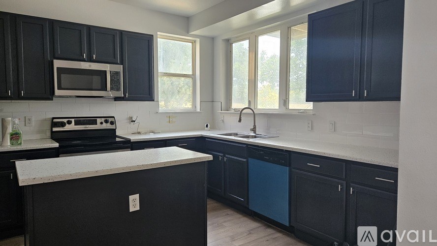 A kitchen with black cabinets and a white countertop.