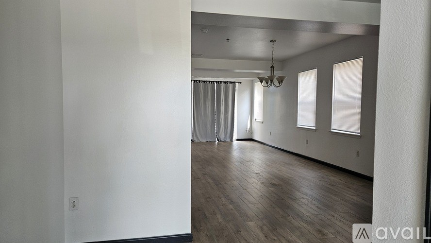 A room with wooden flooring and a window with blinds.