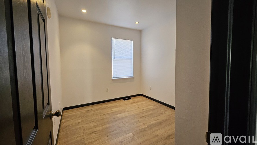 A room with wooden flooring and a window.