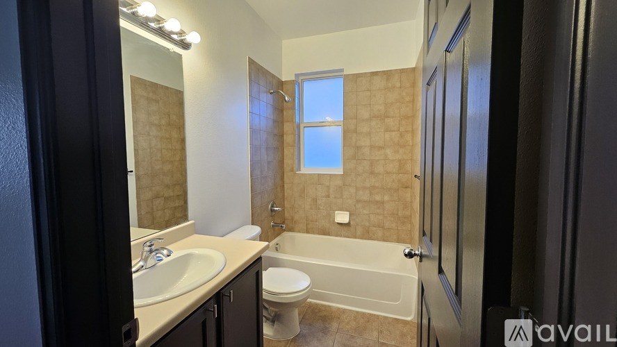 A bathroom with a tub, toilet, and sink.