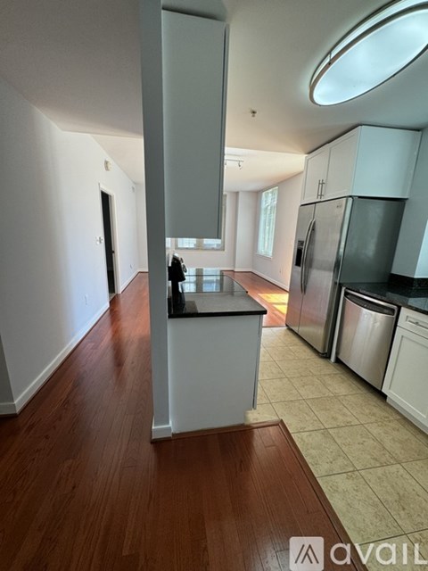 A kitchen with white cabinets and a wooden floor.
