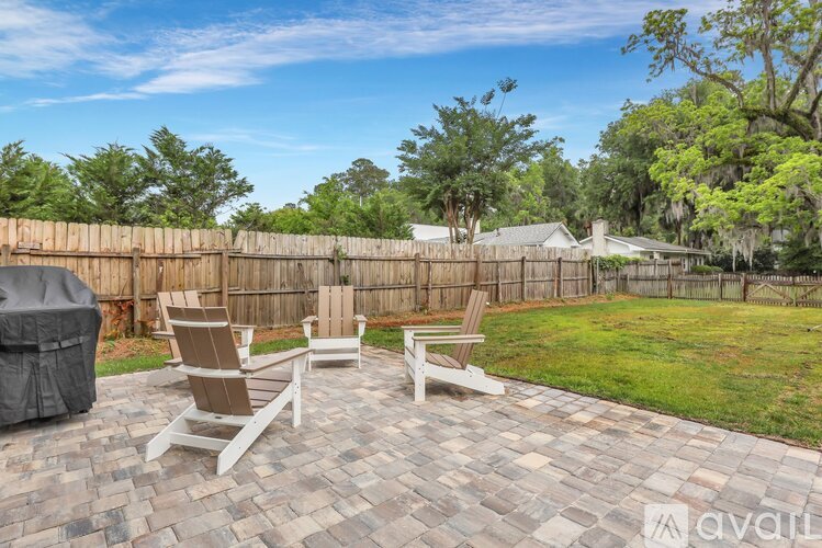 A patio with four chairs and a hot tub.
