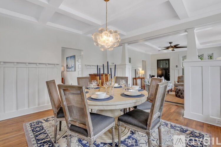 A dining room with a white table and chairs.