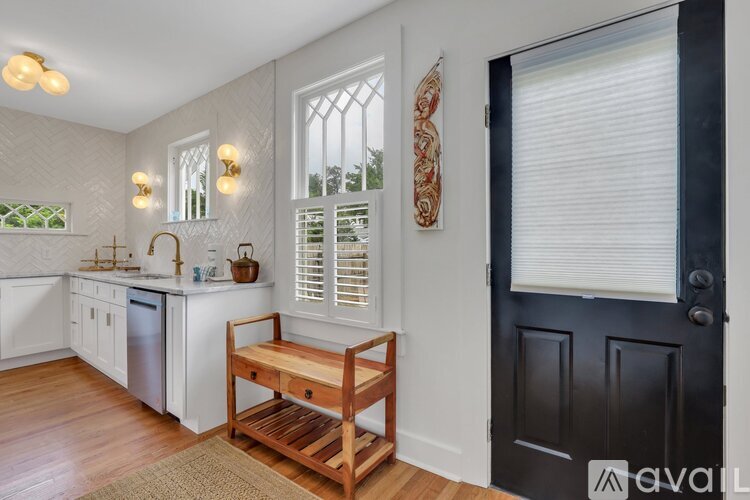 A kitchen with white cabinets and a black door.