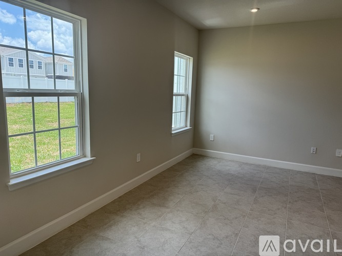 A room with a large window and a view of a building across the street.