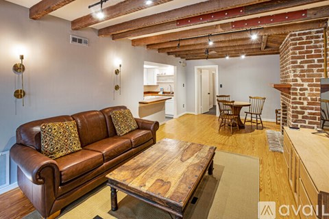 A living room with a brown leather couch and a wooden coffee table.