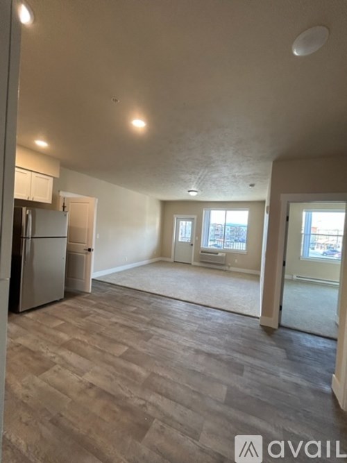 A spacious room with a kitchen area and a window overlooking a balcony.