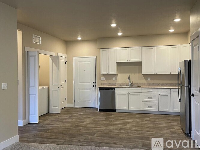A kitchen with white cabinets and a refrigerator.