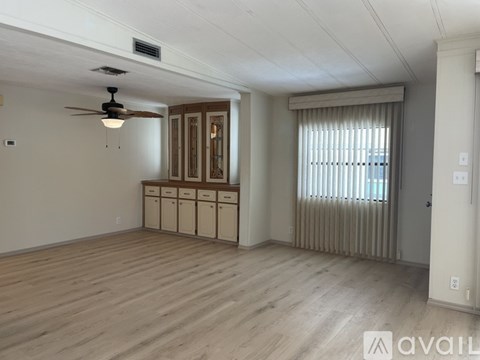 A room with wooden floors and a ceiling fan.