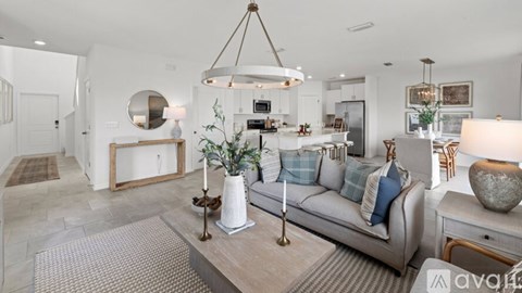 A well-lit, modern living room with a grey sofa and a wooden coffee table.