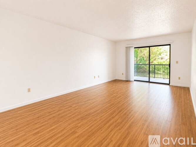 A long hallway with wooden floors and white walls.