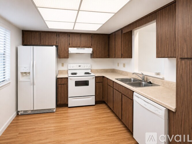 A spacious room with wooden flooring and a large window.