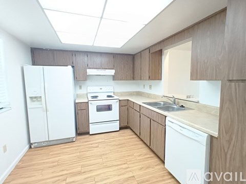 A kitchen with white appliances and wooden cabinets.