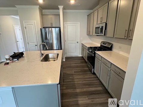 A kitchen with a refrigerator, sink, and stove.