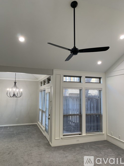 A room with a ceiling fan and a chandelier.