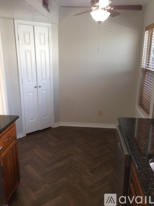 A room with a ceiling fan and a door.