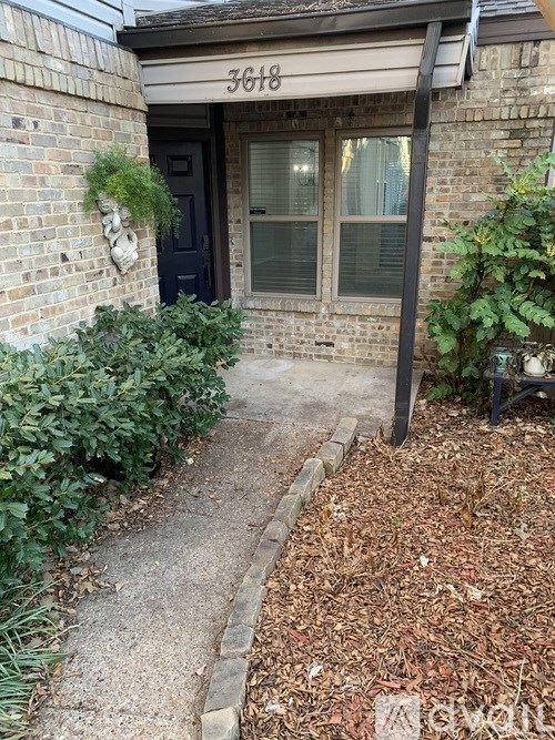 A house numbered 3618 with a blue door and a small garden area.