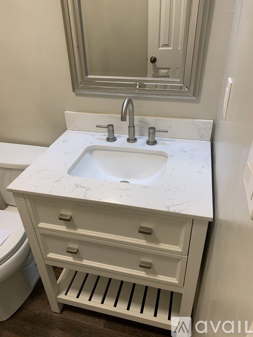 A bathroom with a sink and a mirror above it.