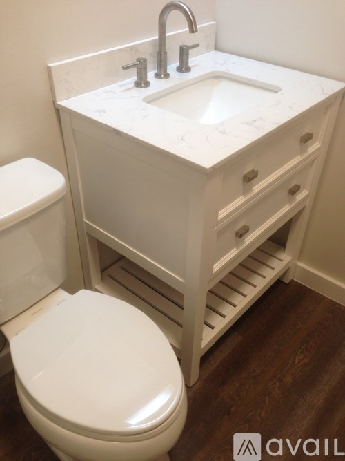 A white toilet and sink in a bathroom.