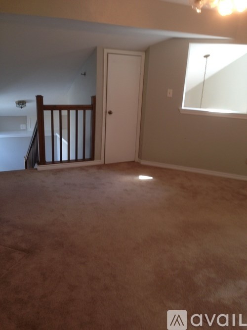 A room with a carpeted floor and a window.
