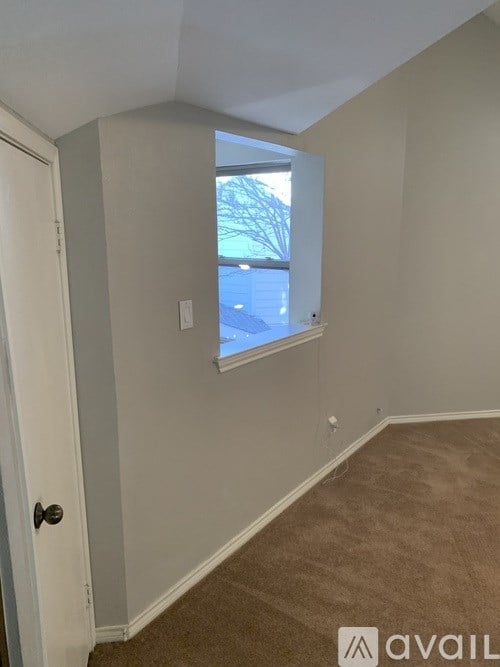 A room with a carpeted floor and a window.