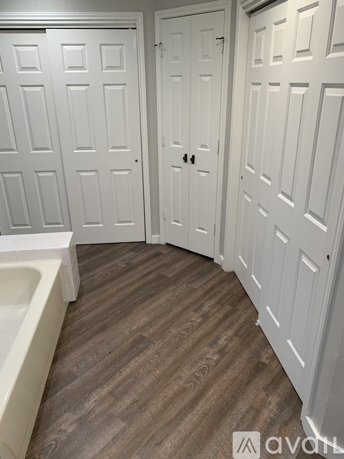 A bathroom with a tub and two doors.
