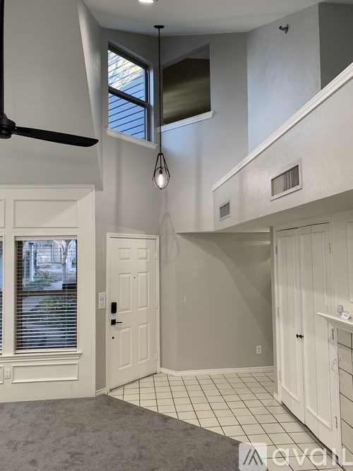 A room with a ceiling fan and a window with blinds.