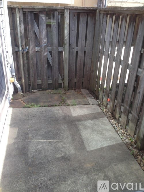 A wooden fence with a gate is in front of a building.
