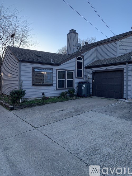 A house with a grey garage door and a chimney.
