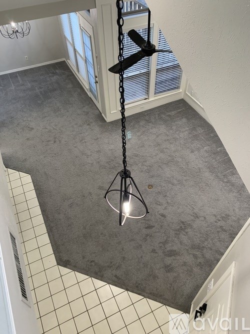 A room with a grey floor and a black and white tiled wall.